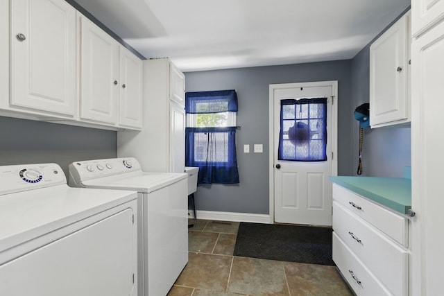 laundry room featuring washer and dryer, cabinet space, and baseboards