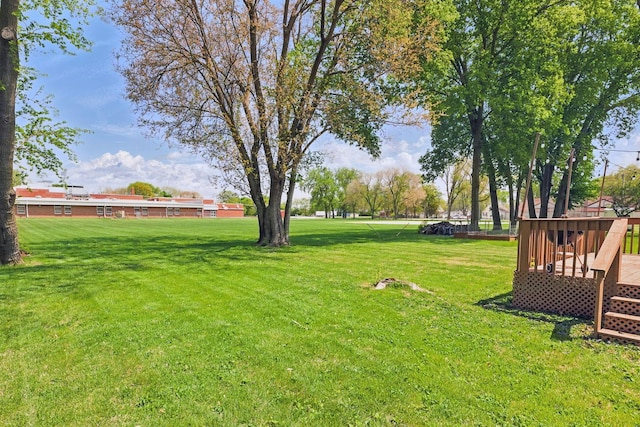 view of grassy yard featuring a wooden deck