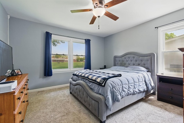 bedroom with light carpet, multiple windows, and baseboards