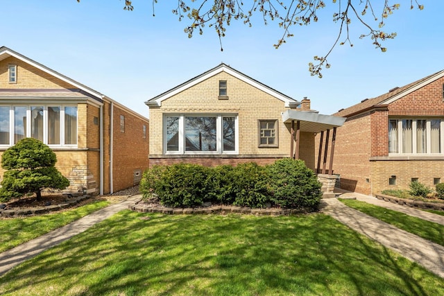 bungalow-style home featuring brick siding and a front yard