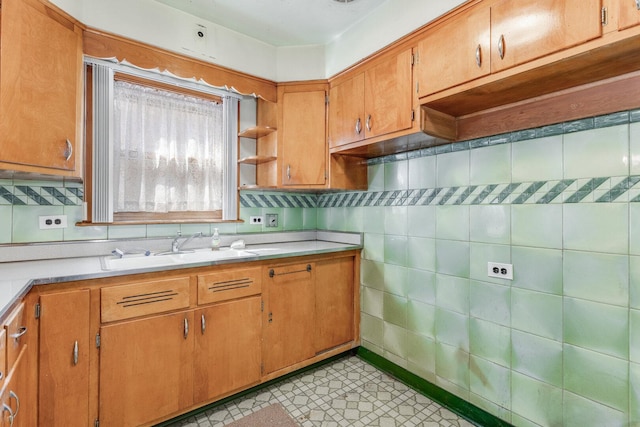 kitchen featuring open shelves, light countertops, a sink, and light tile patterned flooring