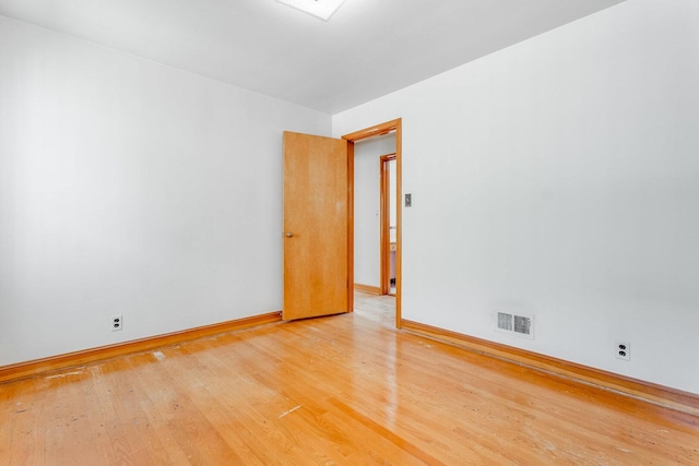 unfurnished room with baseboards, visible vents, and light wood finished floors