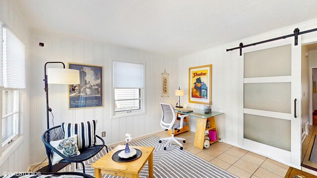 home office featuring tile patterned floors and a barn door