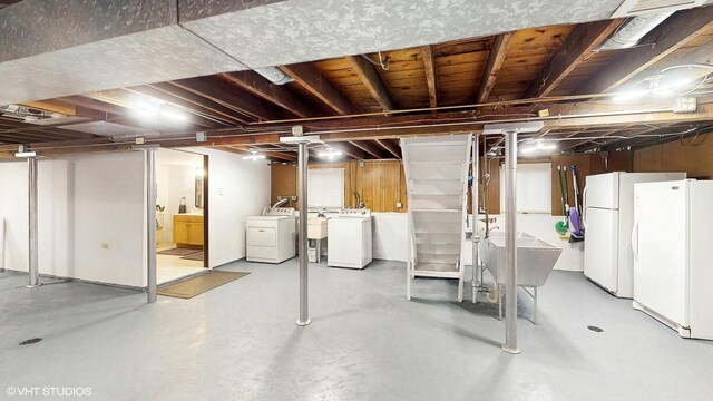 basement featuring freestanding refrigerator and washing machine and clothes dryer