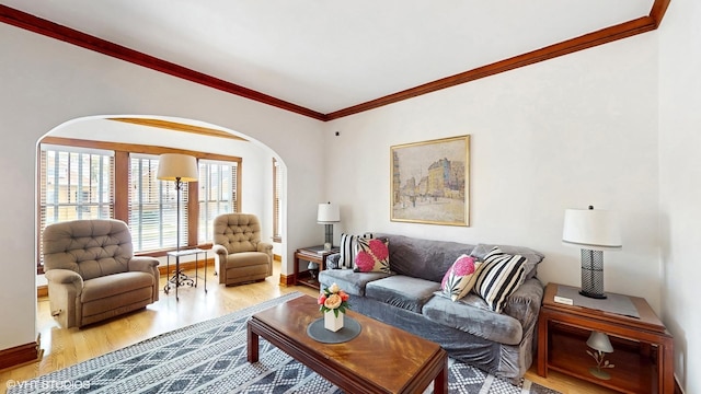 living room with baseboards, arched walkways, wood finished floors, and ornamental molding