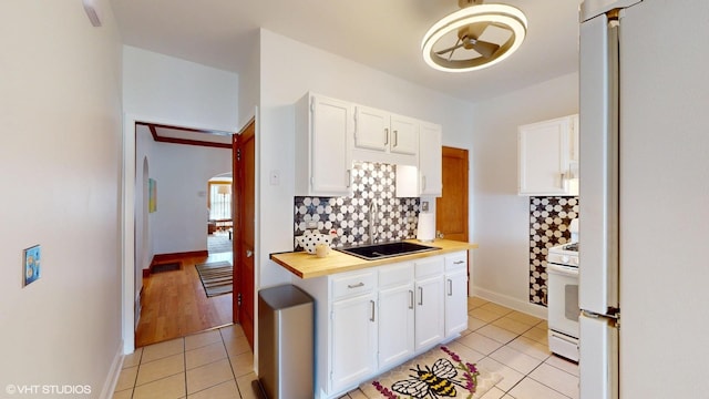 kitchen with white cabinets, white appliances, wooden counters, decorative backsplash, and light tile patterned floors