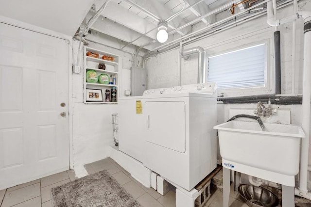 laundry room with a sink, light tile patterned flooring, electric panel, washing machine and dryer, and laundry area