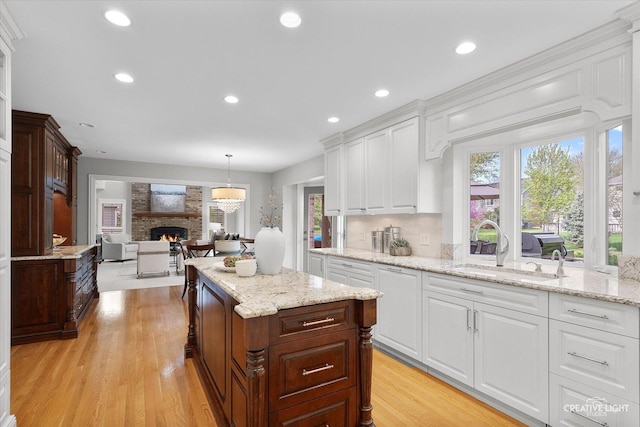 1454 Rill Ct, Naperville, IL 60565 - kitchen with white cabinetry, a large fireplace, a sink, and light wood finished floors
