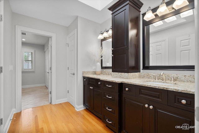 1454 Rill Ct, Naperville, IL 60565 - bathroom with double vanity, visible vents, wood finished floors, a sink, and baseboards