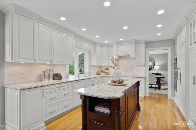 1454 Rill Ct, Naperville, IL 60565 - kitchen featuring light wood-type flooring, decorative backsplash, a sink, and white cabinets