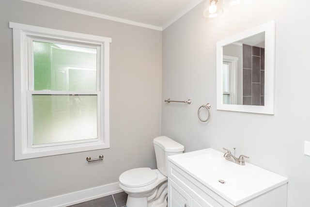bathroom with toilet, ornamental molding, vanity, and baseboards