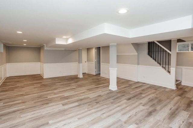 finished below grade area with recessed lighting, wood finished floors, a wainscoted wall, and stairway