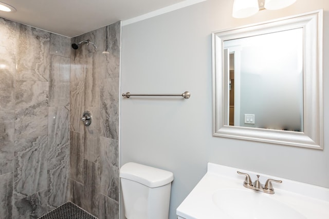 full bath with tiled shower, vanity, and toilet