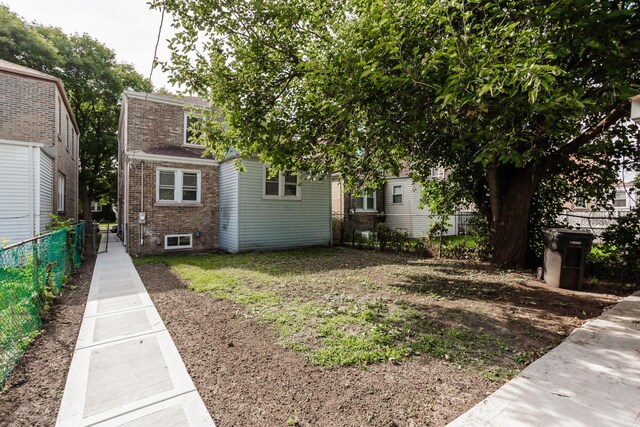 exterior space featuring brick siding and fence