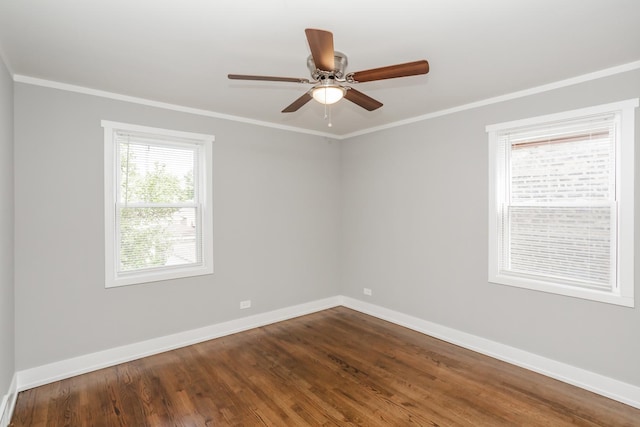 spare room featuring dark wood-type flooring, ceiling fan, baseboards, and ornamental molding