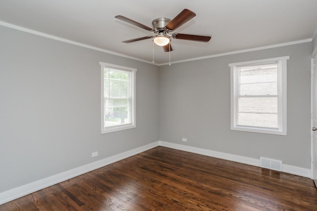 spare room featuring visible vents, a ceiling fan, ornamental molding, dark wood-type flooring, and baseboards