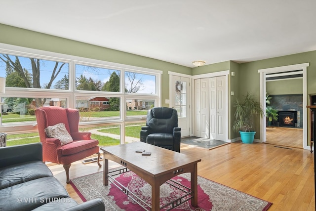 living area with wood finished floors and a lit fireplace