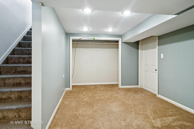 finished below grade area with baseboards, stairway, and carpet