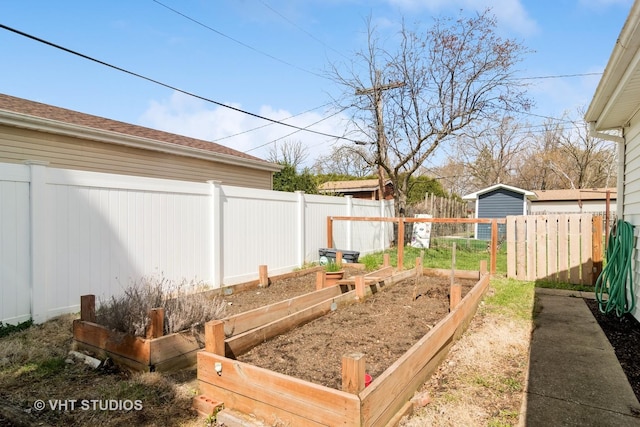 view of yard featuring fence and a vegetable garden