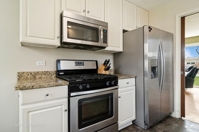 kitchen featuring white cabinets, stainless steel appliances, and light stone counters