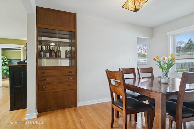 dining room featuring baseboards and light wood-type flooring