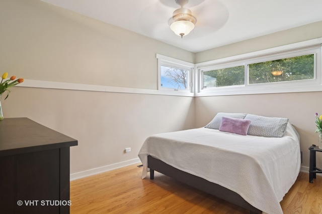 bedroom with light wood finished floors, ceiling fan, and baseboards