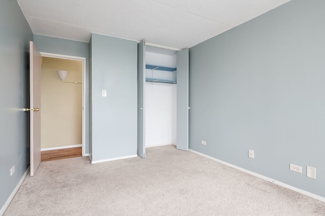 unfurnished bedroom featuring baseboards, a closet, and carpet