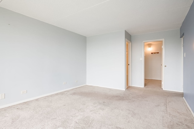 carpeted spare room featuring baseboards