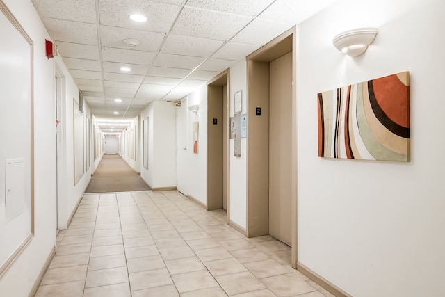 corridor featuring recessed lighting, elevator, a drop ceiling, and baseboards