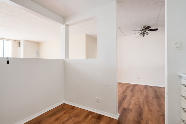 unfurnished room with baseboards, a ceiling fan, and wood finished floors