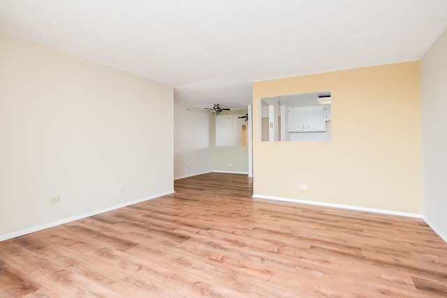empty room featuring baseboards and light wood-style floors