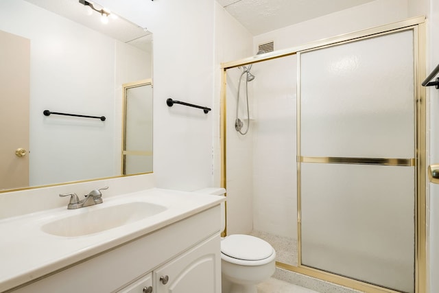 full bath with toilet, vanity, and a stall shower