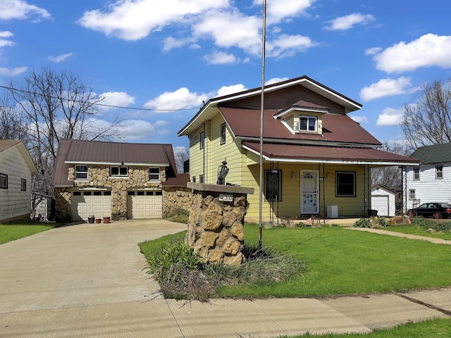 view of front facade featuring driveway, a garage, a front yard, and metal roof