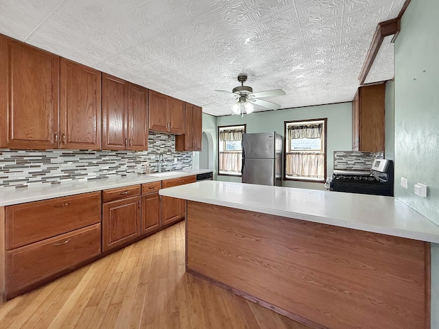 kitchen with backsplash, light countertops, an ornate ceiling, and stainless steel appliances