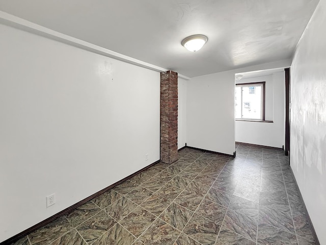 unfurnished room featuring baseboards