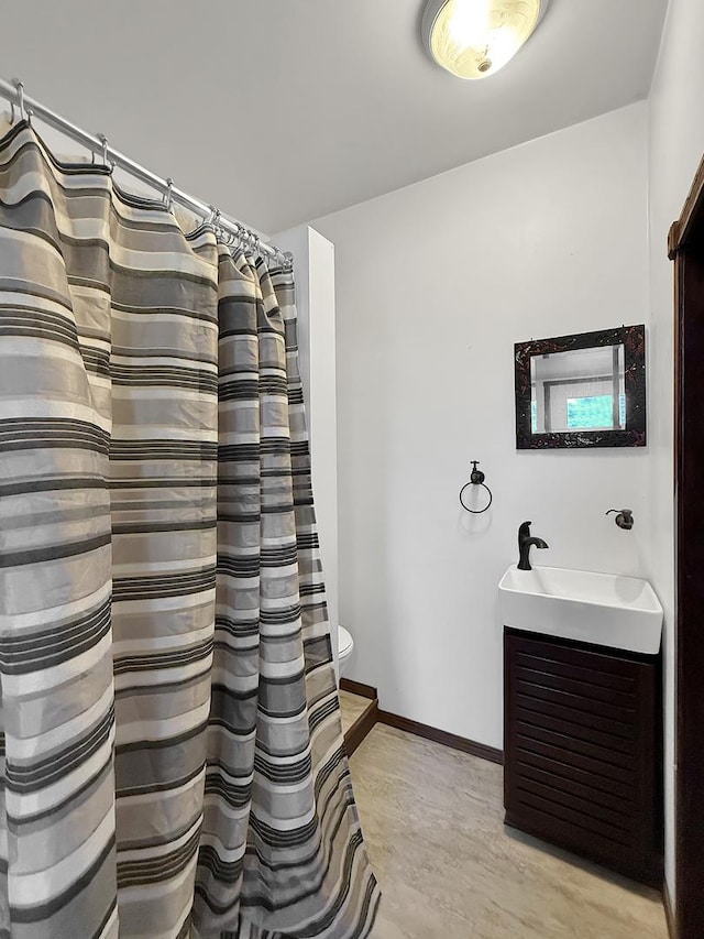 full bath featuring curtained shower, baseboards, toilet, and vanity