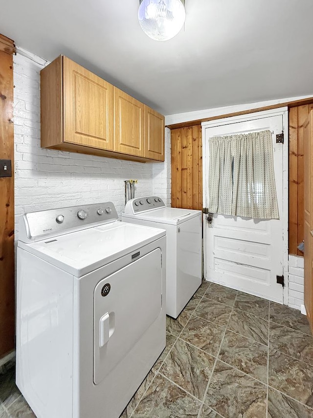 laundry room featuring washing machine and clothes dryer and cabinet space