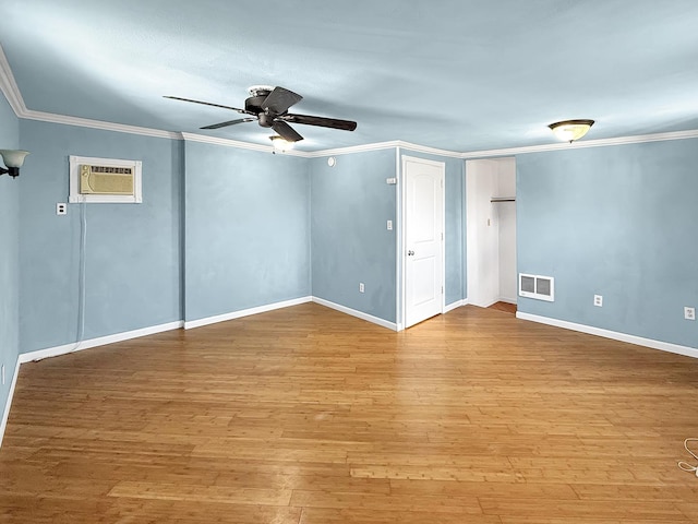 empty room with visible vents, baseboards, a wall mounted AC, hardwood / wood-style flooring, and ceiling fan