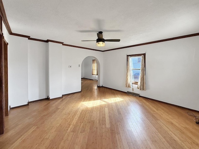 empty room featuring arched walkways, a textured ceiling, light wood-type flooring, visible vents, and ceiling fan