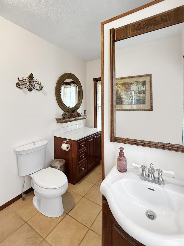 bathroom with baseboards, tile patterned floors, vanity, and toilet