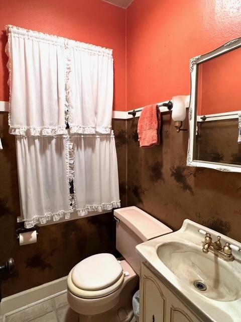 half bathroom with toilet and vanity