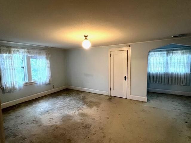 spare room with baseboards and carpet