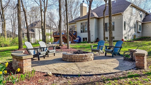 view of patio with a wooden deck, a fire pit, and stairs