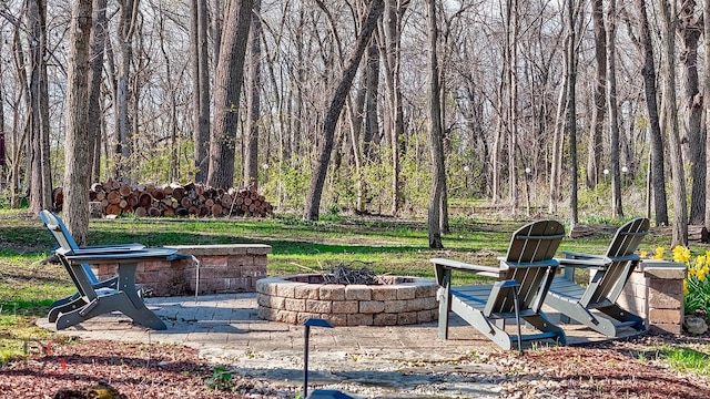 view of yard featuring an outdoor fire pit and a view of trees