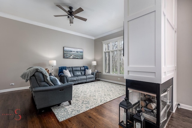 living area with dark wood finished floors, baseboards, a ceiling fan, and crown molding