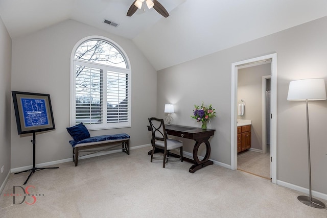 office area with lofted ceiling, visible vents, a ceiling fan, light carpet, and baseboards