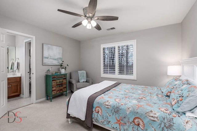 bedroom with a ceiling fan, ensuite bathroom, light colored carpet, baseboards, and visible vents