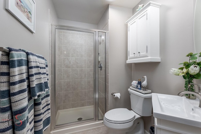 full bath with vanity, a shower stall, and toilet