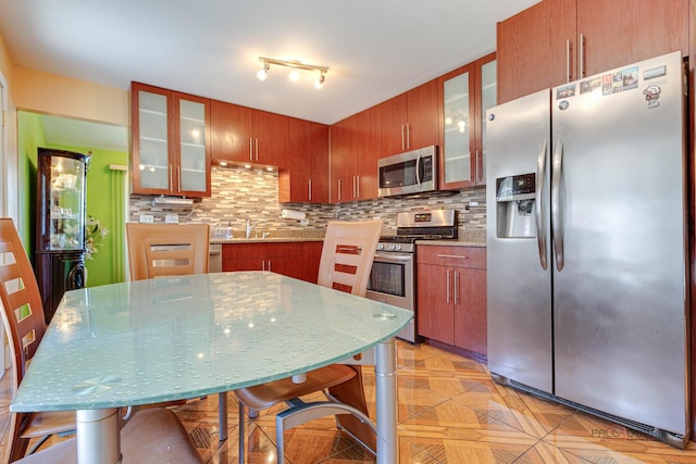 1338 E Best Dr, Arlington Heights, IL 60004 - kitchen featuring brown cabinetry, stainless steel appliances, decorative backsplash, and glass insert cabinets