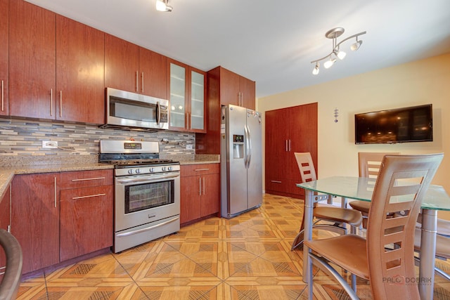 1338 E Best Dr, Arlington Heights, IL 60004 - kitchen with light stone counters, brown cabinets, decorative backsplash, glass insert cabinets, and appliances with stainless steel finishes